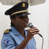 Female police officer speaking into a microphone.