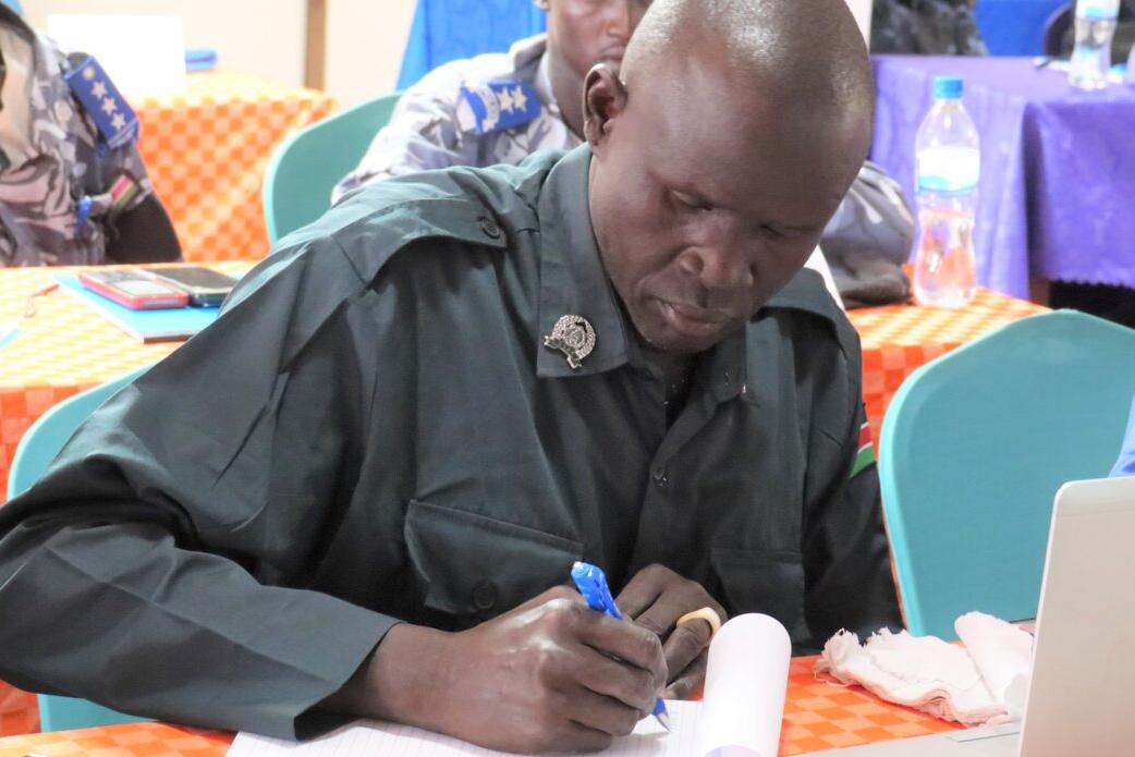 Police officer looking down, writing with a blue pen